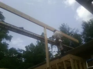 Carpenter setting a ridge beam over a new addition frame — Ice Dam Removal by Roofing Brothers in Carmel Valley