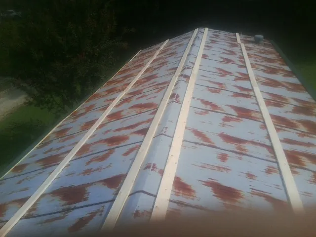 Rusted metal roof panels with new wood purlins before replacement — Storm Damage Roof Repair in Carmel Valley by Roofing Brothers