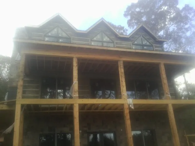 Dormers and porch framing on a large log home under construction — Roof Coating work by our crew in Carmel Valley